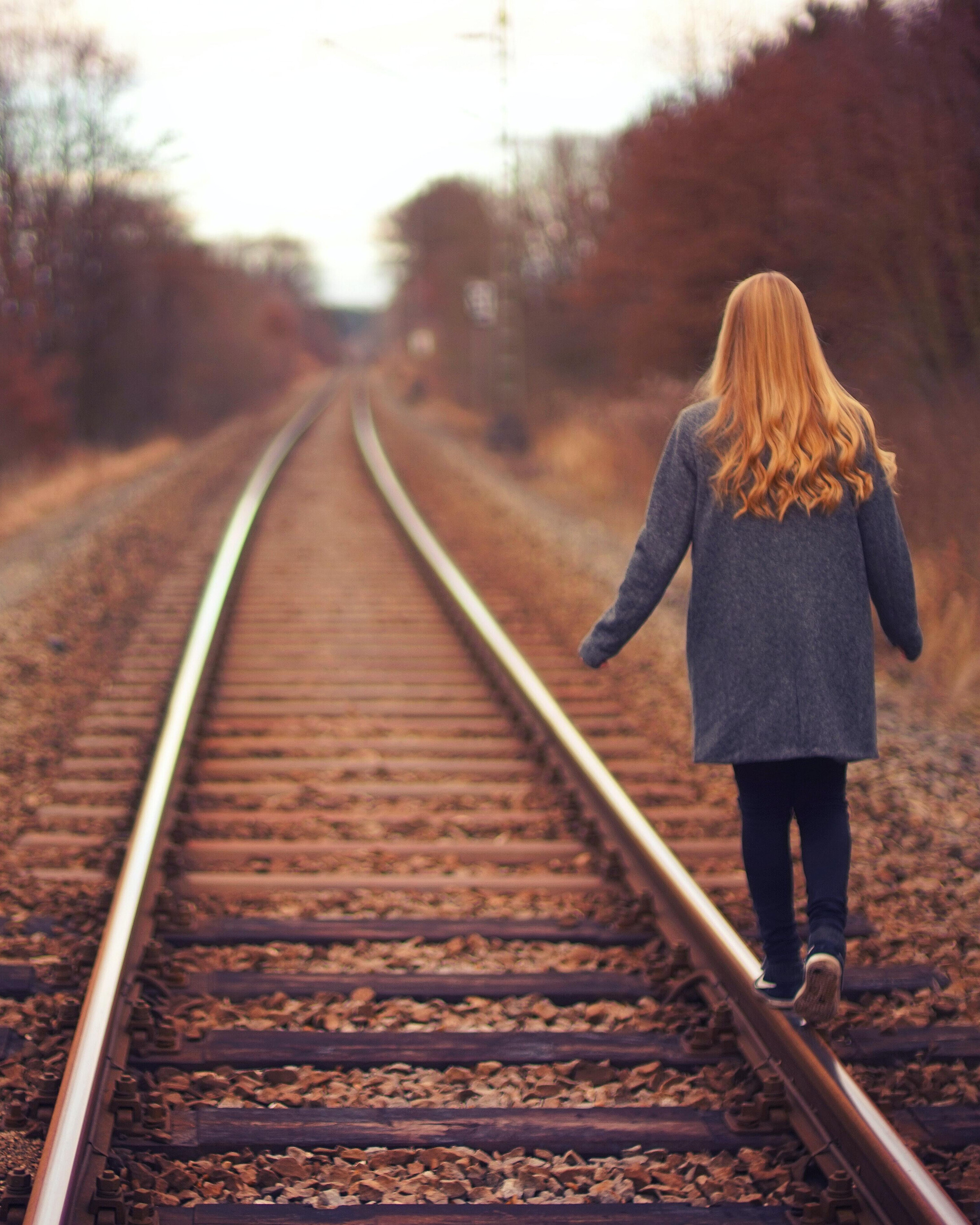 girl walking on train tracks