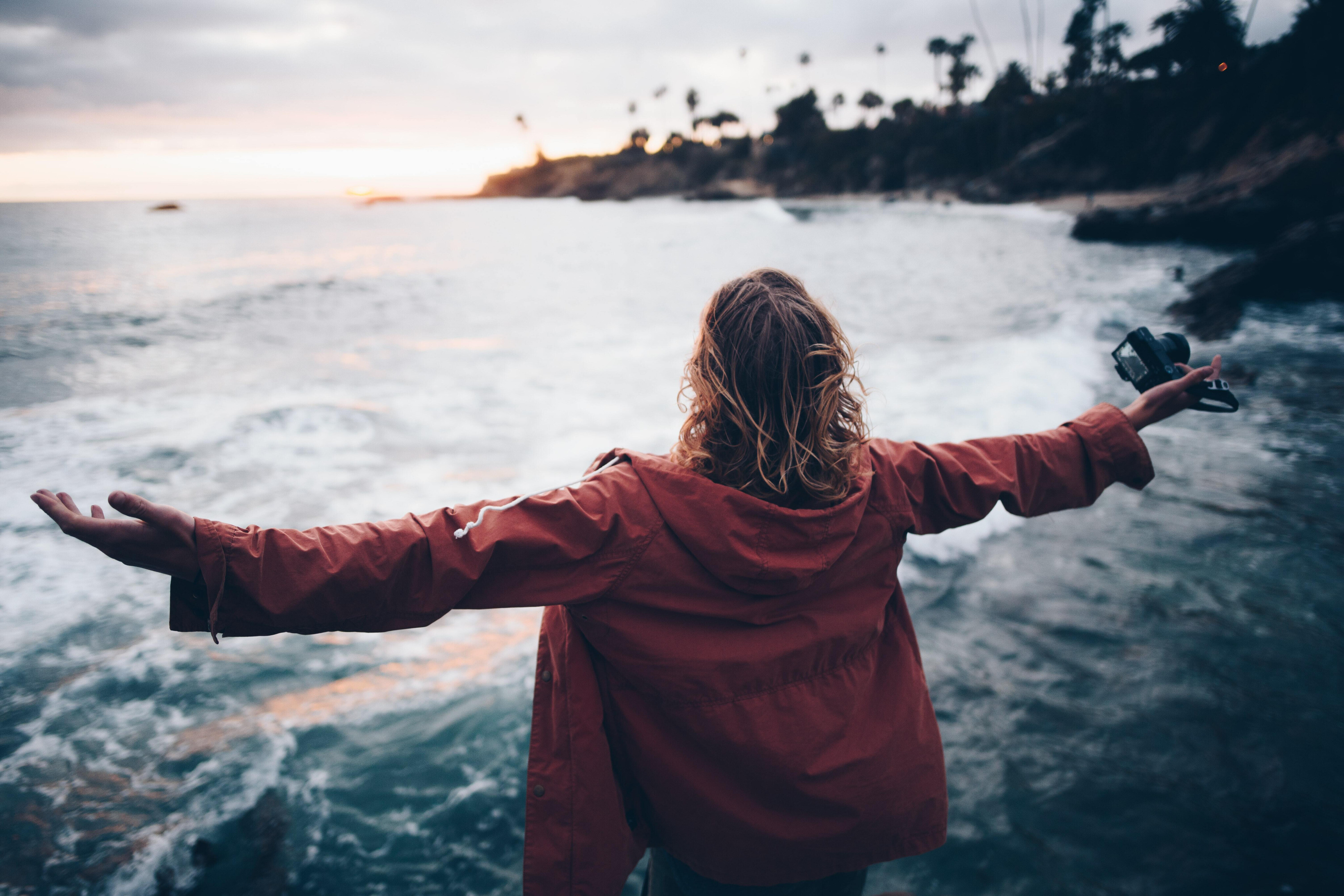 person by the ocean with arms wide open