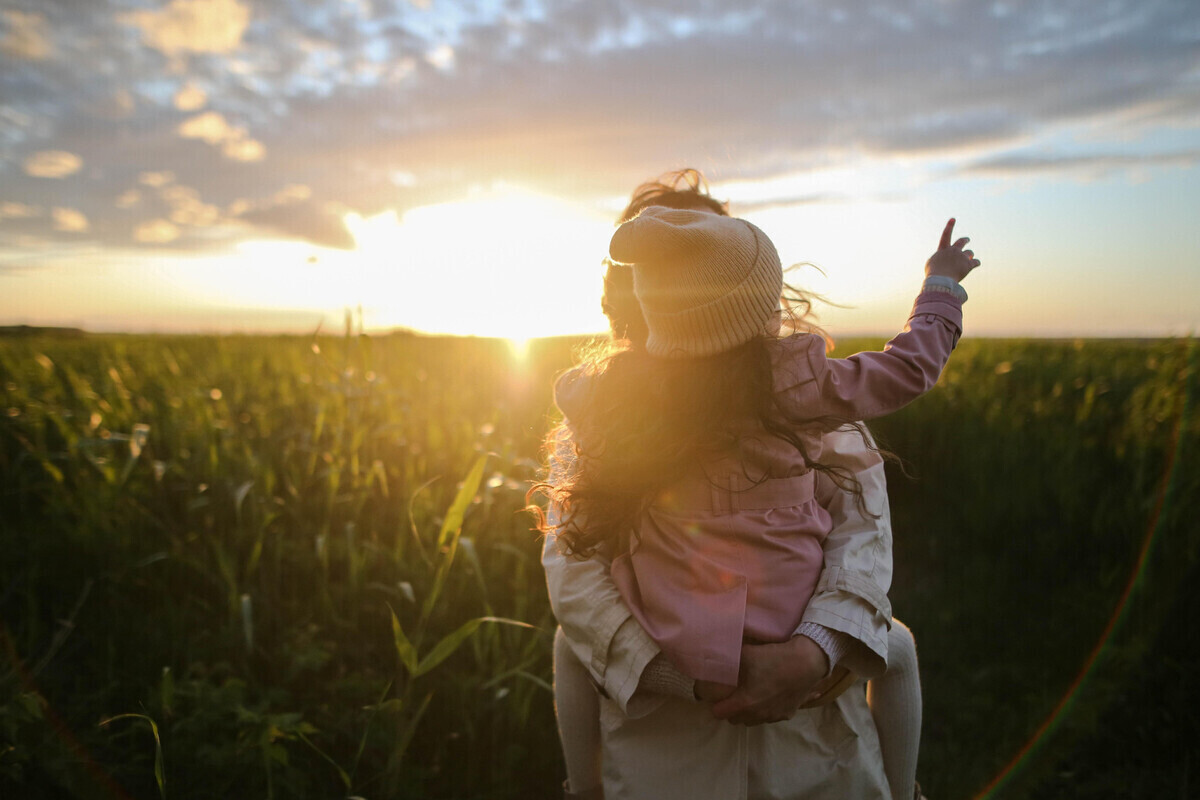 mother and daughter in nature at sunset